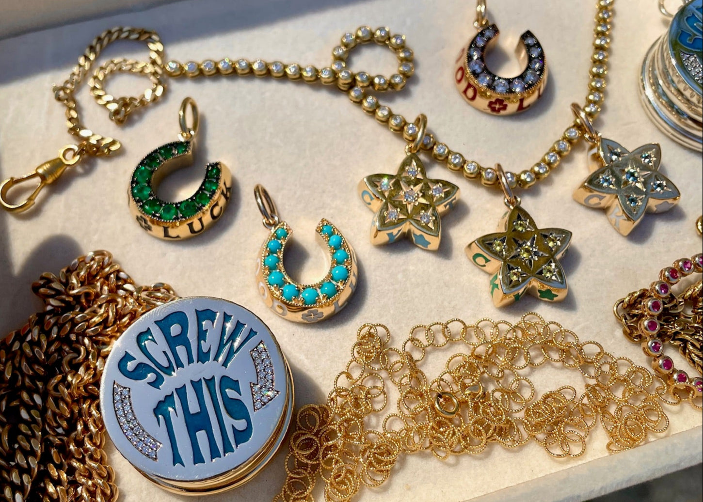 Collection of fine jewelry featuring gold and diamond necklaces, good luck horseshoe pendant,