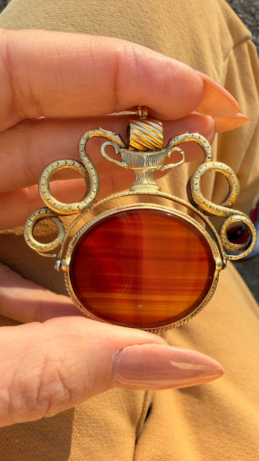 Antique yellow 18K swiveling double snake with urn carnelian pendant