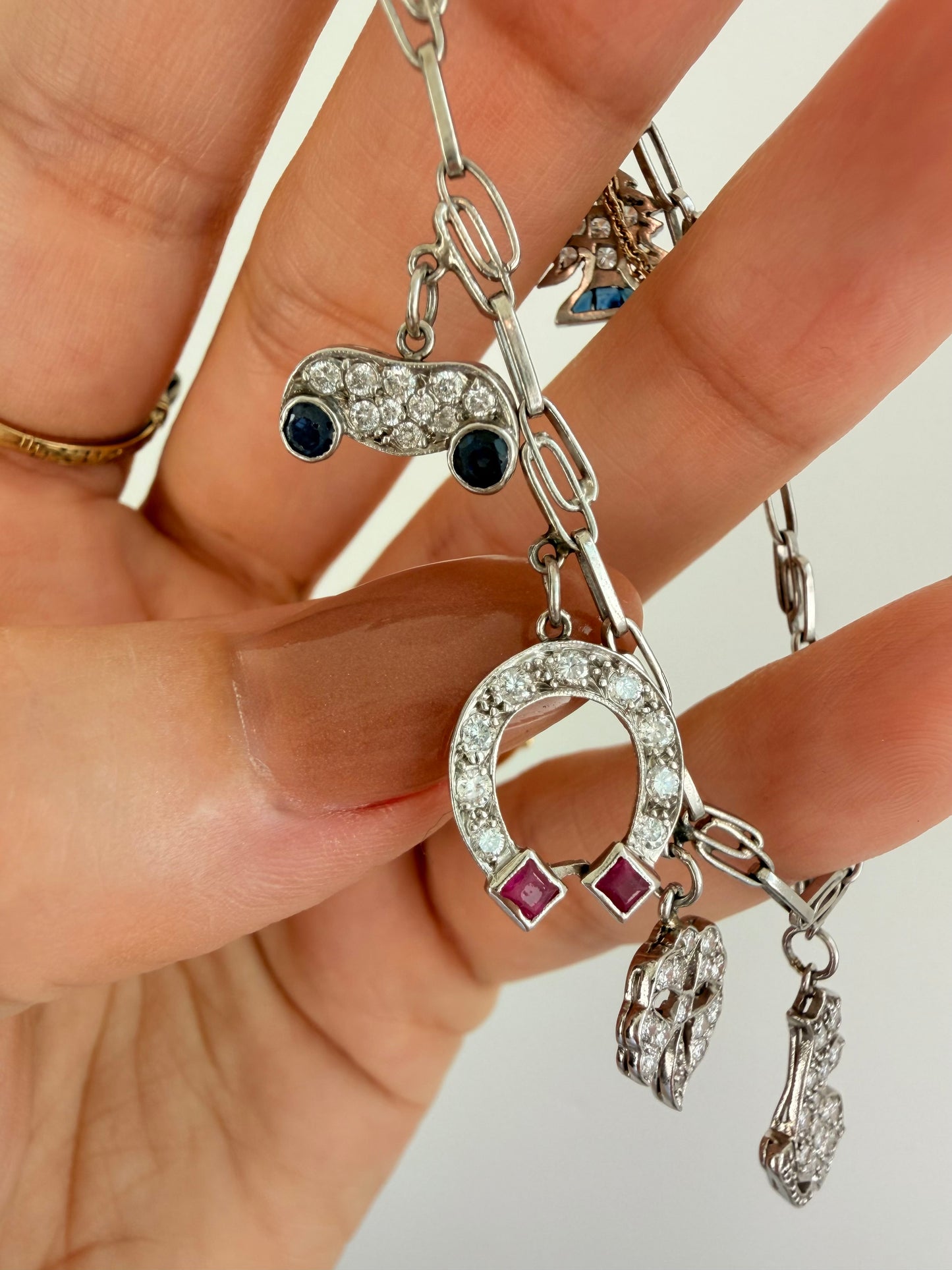 Antique platinum Art Deco charm bracelet with 1 ctw diamonds, sapphires and rubies, 7 inch