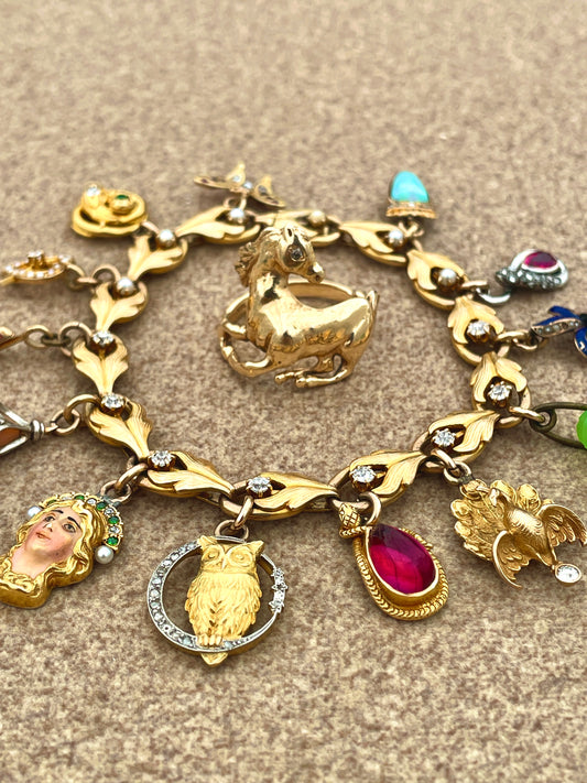 Antique yellow 18K and 14K charm bracelet with old mine cut diamonds, pearls, gemstones and enamel