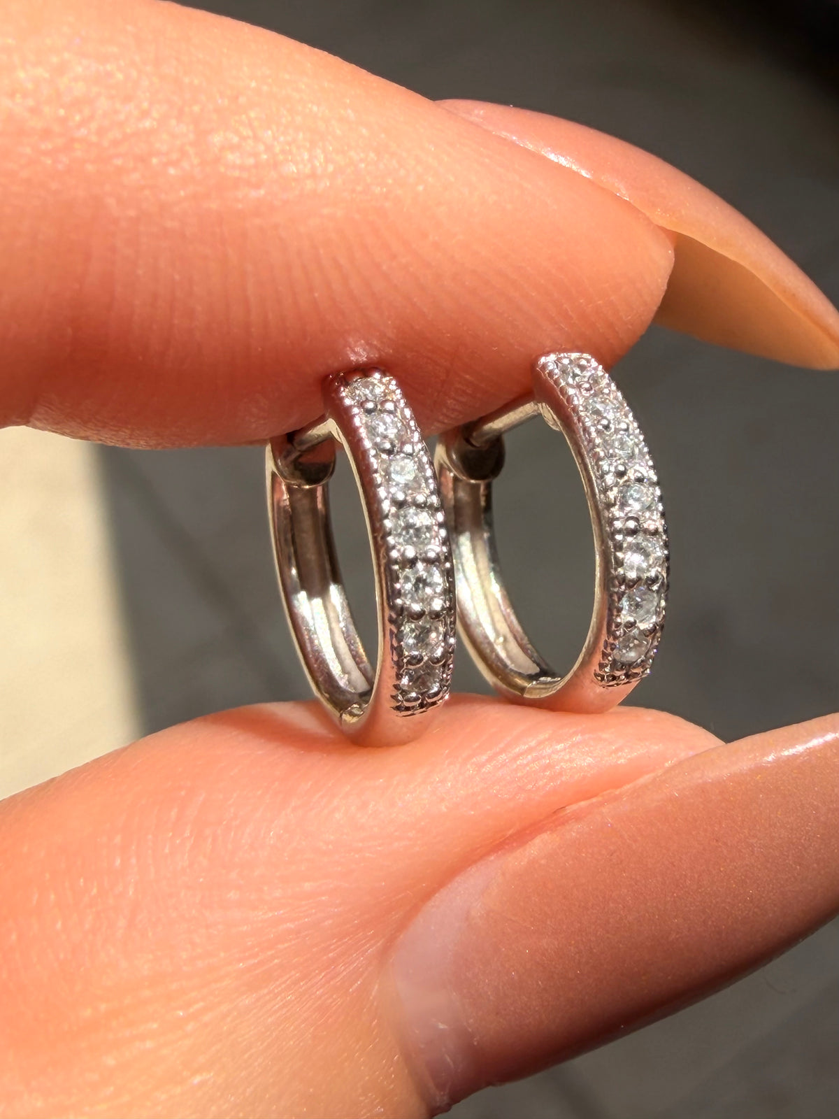 Vintage white 18K approx .13ctw diamond huggies with milgrain detail