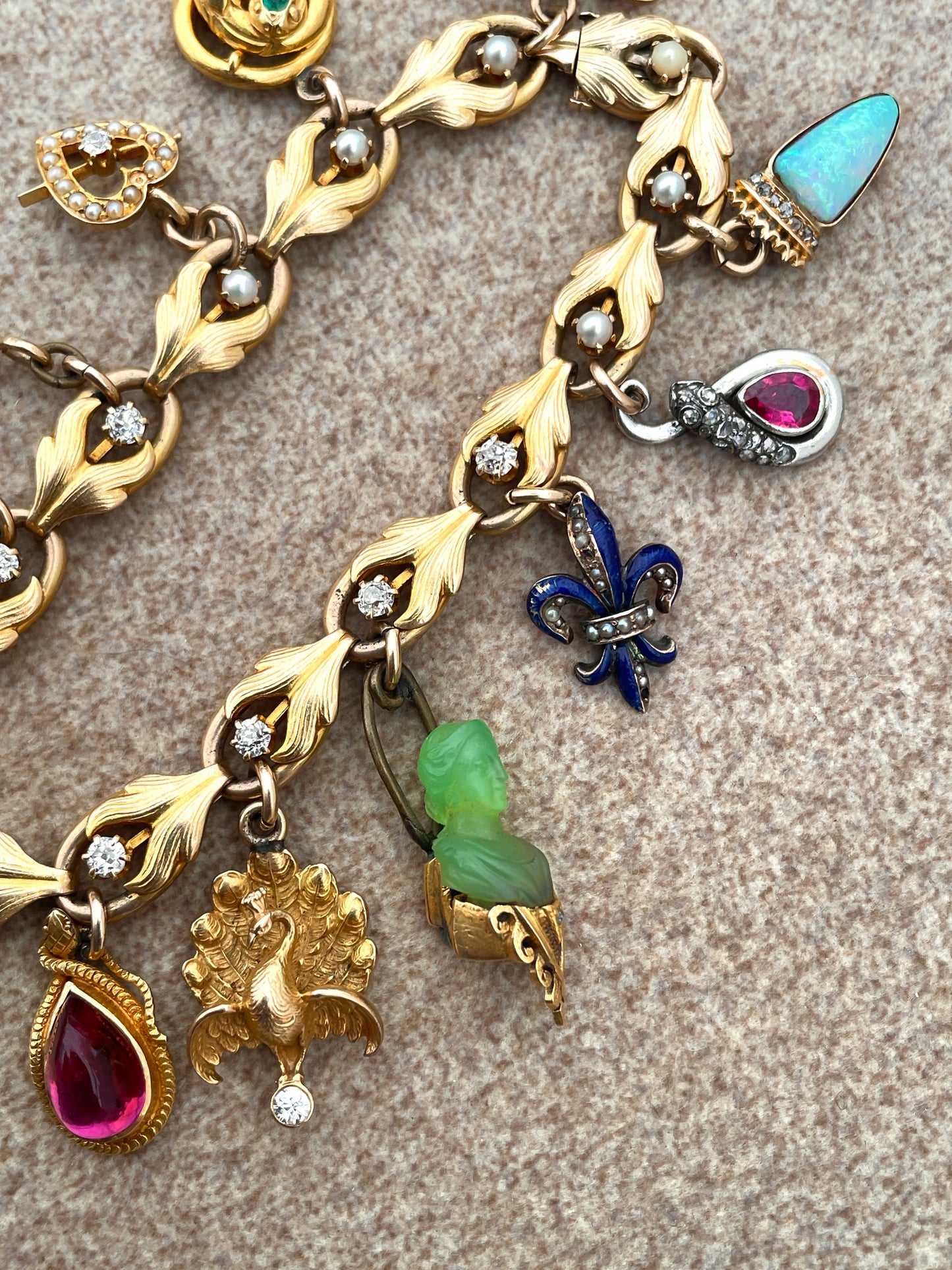 Antique yellow 18K and 14K charm bracelet with old mine cut diamonds, pearls, gemstones and enamel