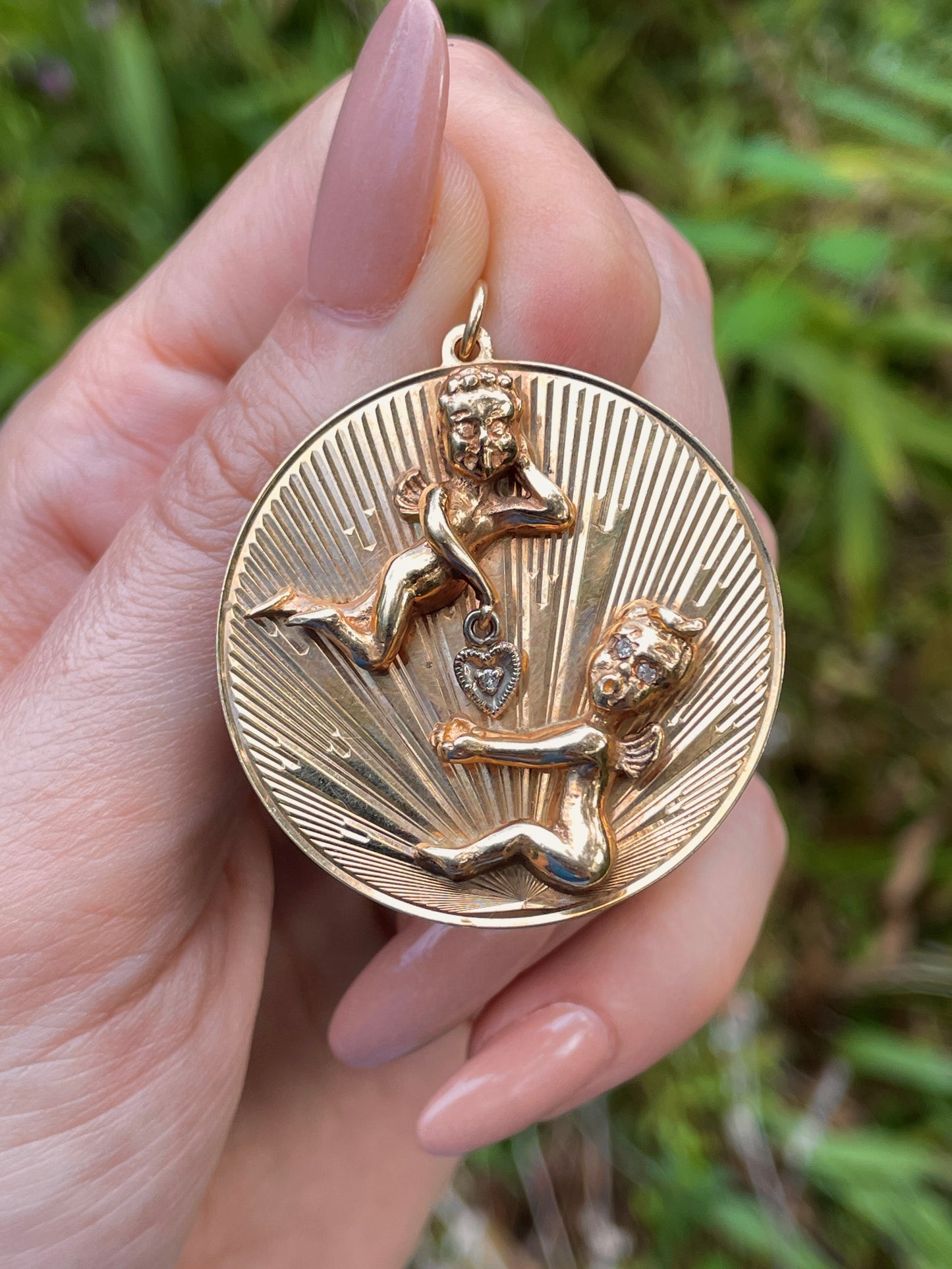Vintage yellow 14K playing cherubs medallion pendant with diamond heart dangle
